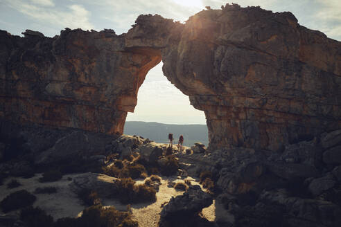 Hikers standing below Cederberg Mountains on sunny day - KOF00066