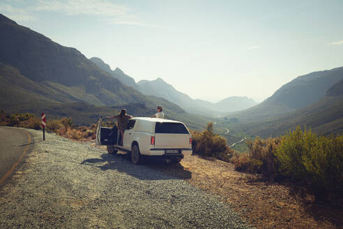 Friends watching mountains from car at roadside - KOF00070