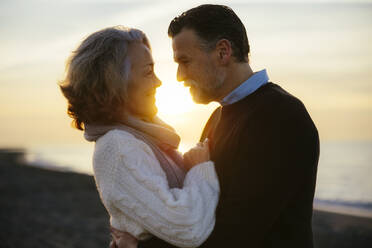 Reifer Mann und Frau umarmen sich bei Sonnenaufgang - EBSF03145