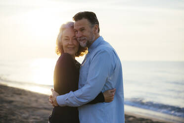 Mature man hugging woman at sunrise - EBSF03163