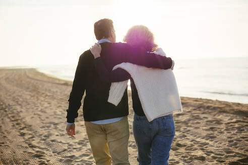 Liebendes reifes Paar, das zusammen am Strand spazieren geht - EBSF03178