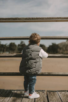 Boy standing by railing looking at view - MTBF01263