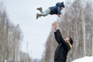 Playful father throwing son in air - ANAF01199