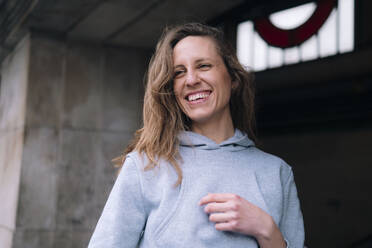 Cheerful woman wearing gray hoodie - AMWF01297