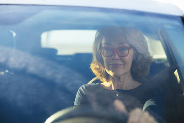 Woman wearing eyeglasses driving car seen through windshield - EBSF03184