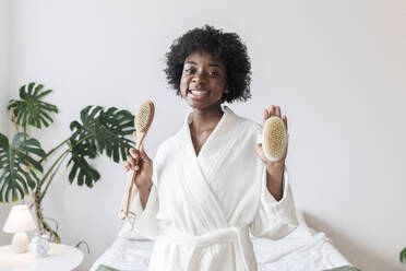 Happy young woman with brushes at home - AAZF00253