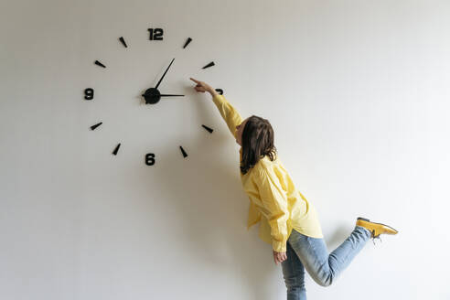 Woman pointing finger on large clock - OSF01521