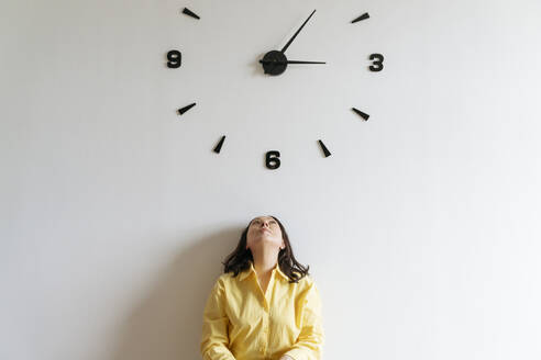 Woman under large clock on wall - OSF01522