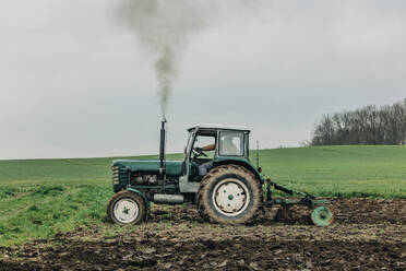 Landwirt pflügt Feld mit Traktor - VSNF00702