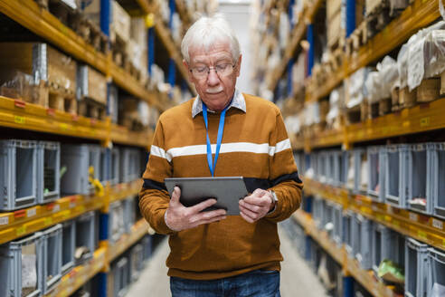 Senior man using tablet PC at warehouse - DIGF19880
