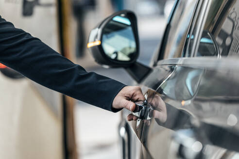 Hand eines Geschäftsmannes beim Öffnen einer Autotür - JSRF02503