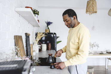 Älterer Mann bereitet Kaffee in der Küche zu Hause zu - EYAF02584
