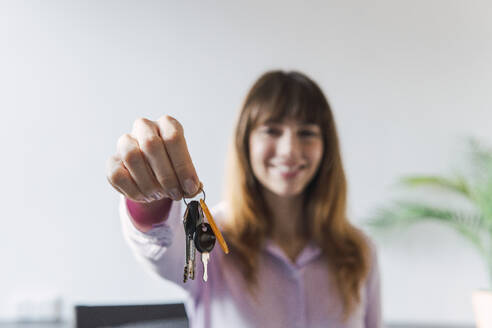 Frau gibt Hausschlüssel im Büro - PNAF05244