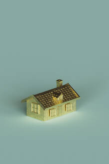 Dreidimensionales Rendering eines goldfarbenen Hauses auf türkisfarbenem Hintergrund - GCAF00281