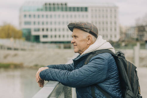 Älterer Mann mit Rucksack am Geländer stehend - VSNF00711