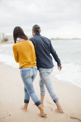 Mann und Frau gehen zusammen am Strand spazieren - JOSEF18479
