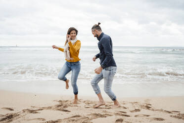 Fröhliches Paar tanzt vor dem Meer am Strand - JOSEF18490