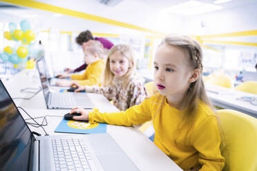 Mädchen mit Laptop im Computerkurs sitzend - NJAF00326