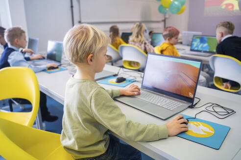 Junge, der im Computerkurs in der Schule am Laptop lernt - NJAF00334