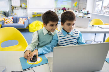 Jungen teilen sich einen Laptop im Computerunterricht in der Schule - NJAF00335