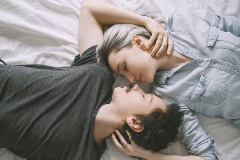 Mann und Frau liegen auf dem Bett und umarmen sich - NDEF00553