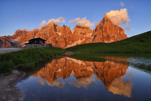 Italien, Trentino-Südtirol, Pale di San Martino-Massiv, das sich in einem kleinen See in der Abenddämmerung spiegelt - RUEF04017