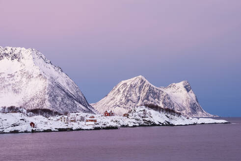 Norwegen, Troms og Finnmark, Abgelegene Hütten am schneebedeckten Ufer der Insel Senja - RUEF04032