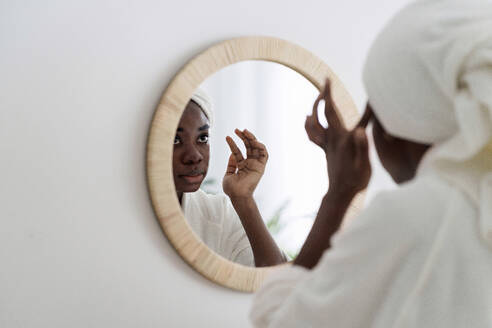 Frau macht Schönheit Routine Blick in den Spiegel zu Hause - AAZF00304
