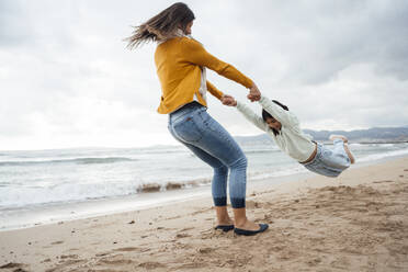 Frau spinnt Tochter und hat Spaß am Strand - JOSEF18528