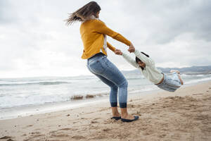 Frau spinnt Tochter und hat Spaß am Strand - JOSEF18528