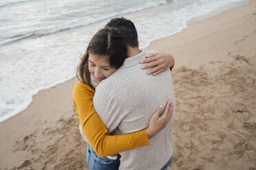 Smiling woman hugging man at beach - JOSEF18531