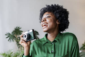 Fröhliche junge Frau mit Kamera im Retrostil - AAZF00362