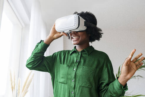 Happy woman wearing virtual reality simulator - AAZF00366
