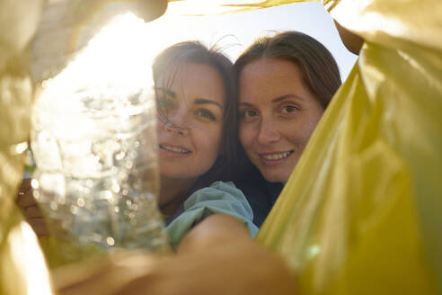 Environmentalists looking in garbage bag on sunny day - ANNF00120