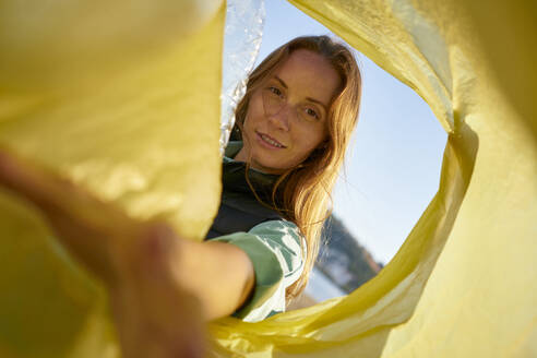 Volunteer keeping plastic bottles in garbage bag - ANNF00122