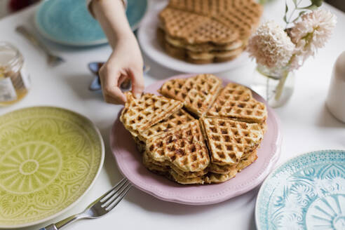 Junge nimmt frische Waffeln vom Teller auf - ONAF00502