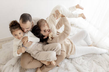Cheerful family spending leisure time sitting on floor - GMLF01404