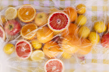 Fresh citrus fruits on table covered with plastic sheet - EGHF00764