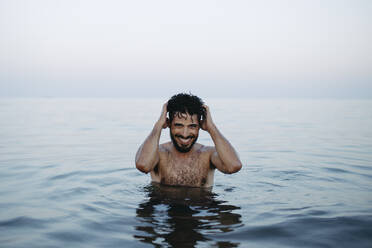 Shirtless glücklicher Mann genießt im Meer - GMLF01406