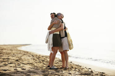 Älterer Mann umarmt Frau, die am Strand steht - EBSF03233
