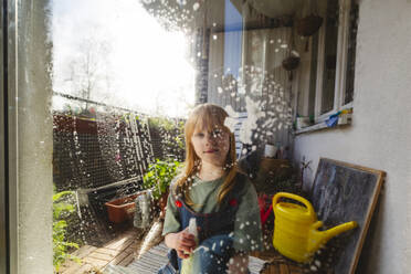 Rothaariges Mädchen putzt Fensterglas - IHF01346
