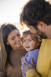 Cute daughter with father and mother at beach - JOSEF18554