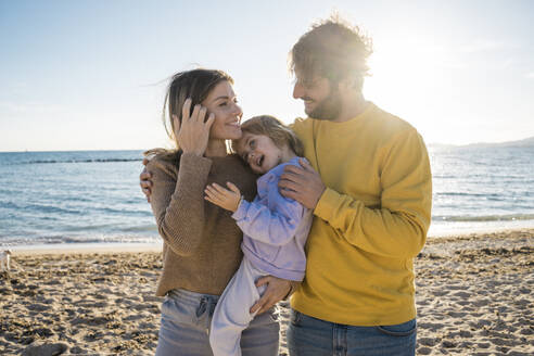 Mann mit Arm um Frau und Tochter am Strand - JOSEF18575