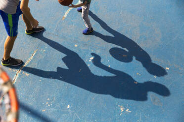 Mann spielt Basketball mit seinem Sohn auf einem Sportplatz - IKF00202