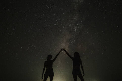 Zwei Frauen berühren sich und stehen vor den Sternen - GMLF01455