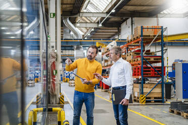 Businessman and manager discussing in production hall at factory - DIGF19960