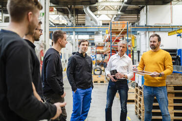 Manager bei einer Besprechung mit Mitarbeitern in der Fabrik - DIGF19981