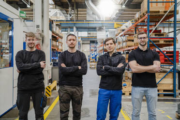 Employees with arms crossed standing in factory - DIGF19986
