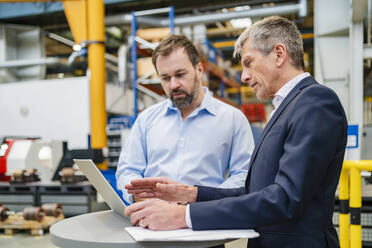 Geschäftsmann klärt Manager über Laptop in Fabrik auf - DIGF20020