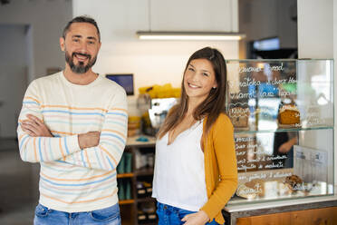 Lächelnde Coffeeshop-Besitzer, die zusammen im Cafe stehen - JOSEF18592